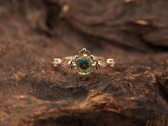 an opal ring sits on top of a piece of wood