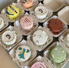 twelve decorated cupcakes are in small trays