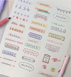 a notebook with some stickers on it next to a pink pen and two pens