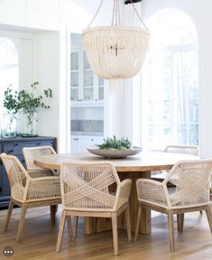 a dining room table with chairs and a chandelier hanging from it's ceiling