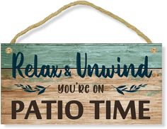 a wooden sign that says relax and unwind you're on patio time