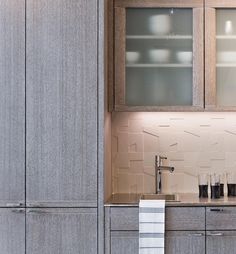 a kitchen counter with a bowl on top of it and some cups in front of it