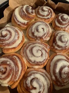 a pan filled with cinnamon rolls covered in icing