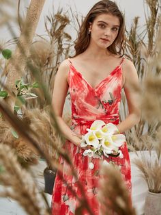 a woman in a red and white dress holding flowers