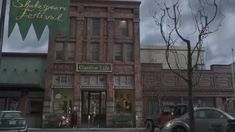 an old brick building on the corner of a street with cars parked in front of it