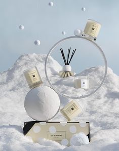 an advertisement with candles and soaps floating in the air on snow covered ground, surrounded by bubbles