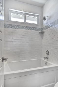 a white bathroom with a toilet and bathtub