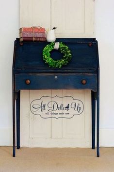 a blue desk with a wreath on top and books sitting on it's side