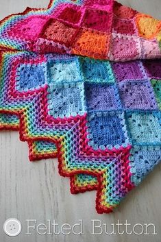 several crocheted squares sitting on top of a wooden table