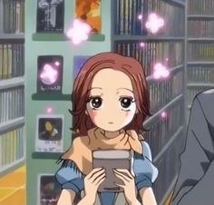 an anime character is holding a tablet in front of bookshelves and looking at the screen