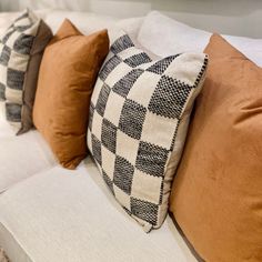 four pillows are lined up on a white couch