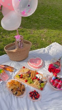 a table topped with lots of food and balloons