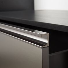 a close up view of the handle on a stainless steel dishwasher with black countertop