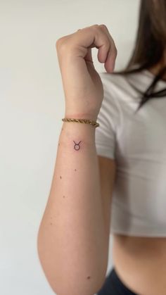 a woman's arm with a small tattoo on the left side of her arm