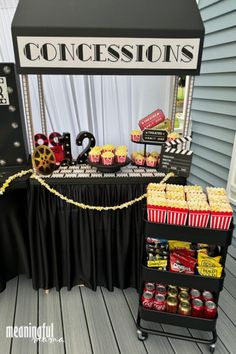 an outdoor movie party with popcorns and snacks on the table, along with a sign that says concession