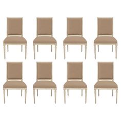 six chairs with beige upholstered back and white legs, all facing different directions