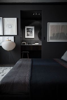 a bedroom with black walls and pictures on the wall