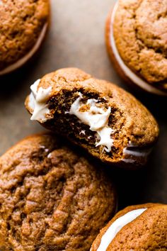 chocolate chip cookies with white frosting on top and one cookie in the middle is half eaten