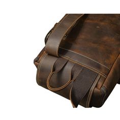 a brown leather bag with straps on the bottom and side, sitting against a white background