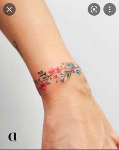 a woman's hand with a flower tattoo on the left side of her wrist