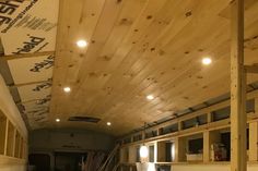 the inside of a truck with wood planks on the ceiling and lights hanging from the ceiling