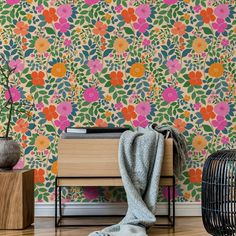 a colorful wallpaper with flowers and leaves in the background is next to a black birdcage