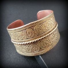 Vintage wide brass bracelet, chunky bracelet, Wide open wrist bangle bracelet, Handmade Copper & Brass Bracelet Ethnic Geometric Design Metal -  bronze outside, copper inside Stone -   Size - 6 3/4'' , wide '' Mark -  Circa  before the 2000s  Condition - good condition.  PLEASE NOTE: Vintage jewelry can show signs of wear and discoloration or chipped metal consistent with age. Please look at the pictures carefully. Most were purchased at estate sales, auctions, etc. so they could need cleaning. Adjustable Bohemian Cuff Bracelet With Antique Finish, Bohemian Adjustable Cuff Bracelet With Antique Finish, Bohemian Antique Gold Bracelets For Gift, Bohemian Antique Gold Brass Bracelets, Bohemian Wide Band Engraved Jewelry, Bohemian Gold Engraved Bracelets, Bohemian Gold Engraved Bracelet, Bronze Cuff Bracelet With Intricate Design For Gift, Festival Brass Bangle Cuff Bracelet