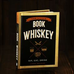 the little book of whiskey by sip, eat, drink is sitting on a table