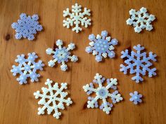 six snowflakes sitting on top of a wooden table