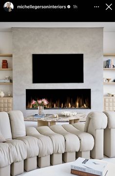 a living room filled with furniture and a flat screen tv mounted on the wall above a fireplace