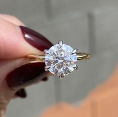 a close up of a person holding a ring with a diamond in it's center