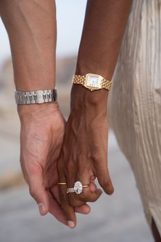 two people holding hands and wearing bracelets on their wrists, one with a diamond in the other's hand