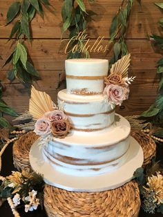 a three tiered wedding cake with flowers on top