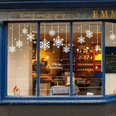 a store front with snowflakes hanging from the windows