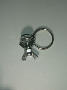 a small metal object sitting on top of a white table next to a pair of scissors