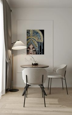 a table with two chairs and a painting on the wall in a living room area