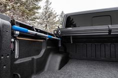 the back end of a pickup truck with its cargo compartment open and two blue handles