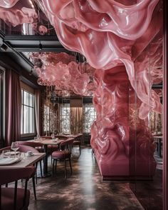 the interior of a restaurant with pink walls and chairs