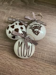 three painted eggs with bows on them sitting on a table