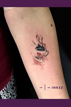 a woman's arm with a tattoo on it that has an image of a tea cup and saucer