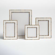 four white and gold frames on a white background with one empty photo in the middle