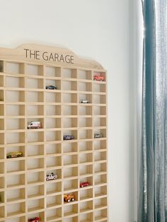 a book shelf with toy cars on it and the garage sign mounted to the wall