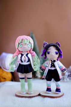 two crocheted dolls standing next to each other