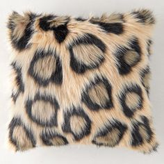 an animal print pillow on a white wall with black spots and circles in the fur