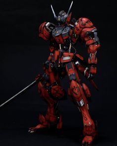 a red and black robot with two swords in his hand, standing on a black background