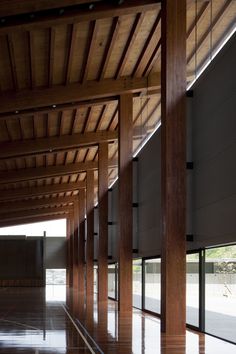 an empty building with wooden columns and windows