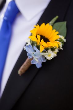 a boutonniere with sunflowers and bluebells on the lapel