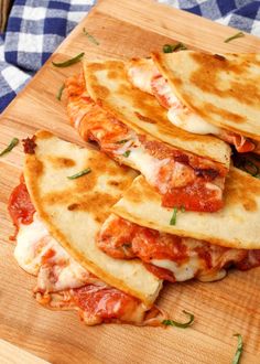 four quesadillas stacked on top of each other on a wooden cutting board