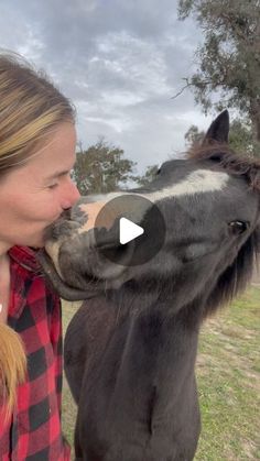 a woman kissing a horse on the nose