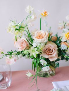 a vase filled with lots of flowers on top of a table next to a plate